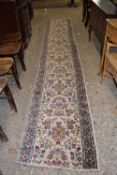 A narrow floral decorated runner carpet 435cm long