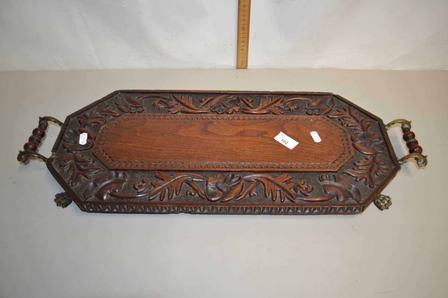 Victorian octagonal two handled serving tray with carved floral decoration and brass paw feet
