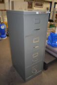 A four drawer grey metal filing cabinet