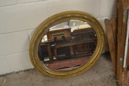 An oval gilt framed bevelled wall mirror