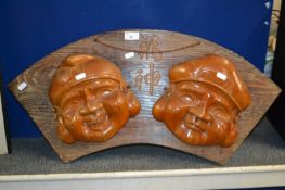 Two Japanese wall masks on wooden backing