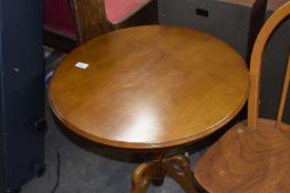 A reproduction round pedestal coffee table