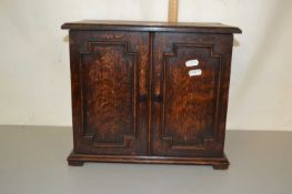 An oak table top cabinet with mitred decoration
