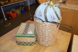 A wicker sewing box together with a waste paper basket and floral decorated lamp