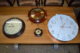 Group of three modern wall clocks and a barometer
