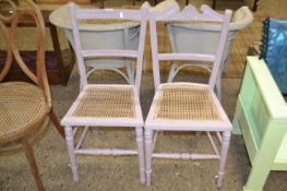 A pair of painted cane seated bedroom chairs