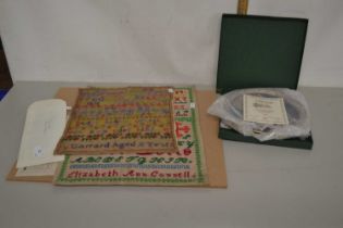Two unframed needlework samplers together with two boxed Minton Arthurian Legend plates