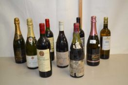 Group of nine bottles of various red wine and champagne
