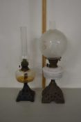 Two oil lamps with cast metal bases