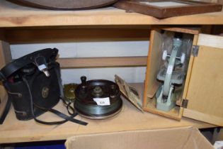 A pair of binoculars, a microscope and a bakelite Estuary Champion fishing reel