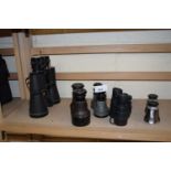 A pair of Grosvenor 12 x 50 binoculars together with another smaller pair and three pairs of opera