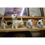 A pair of novelty dog mugs together with a figure of a Highland Terrier and one of a Bassett