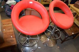Pair of red upholstered and chrome finish bar stools