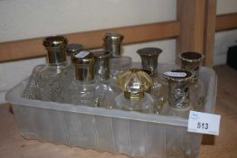 Quantity of assorted perfume bottles with white metal tops
