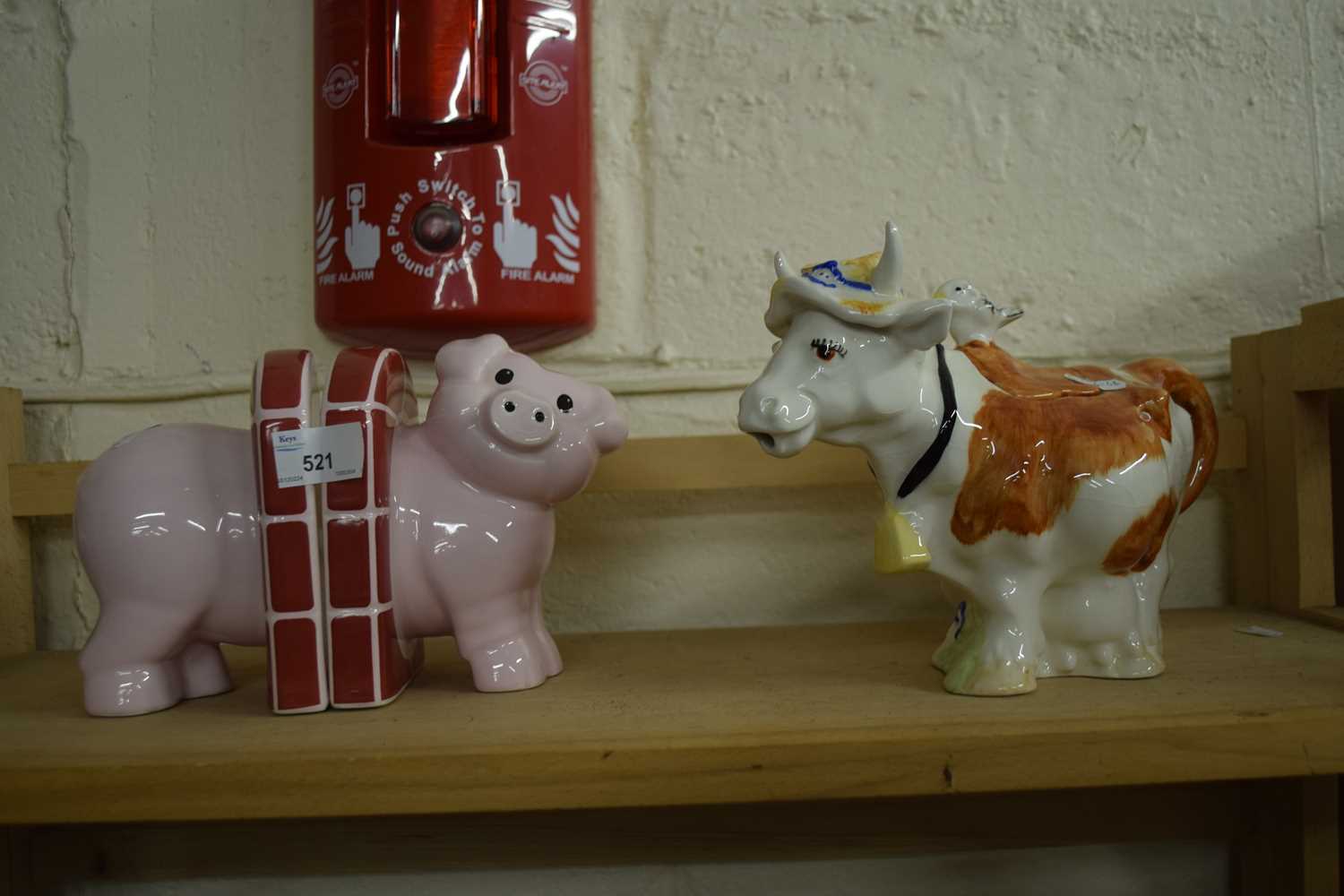 A novelty cow teapot and a pair of pig book ends