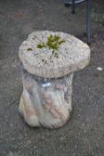 A concrete tree stump plant pot stand