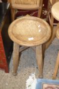 An oak circular top stool on tapering legs