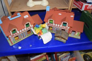 Two Fisher Price fold-out toy houses and contents