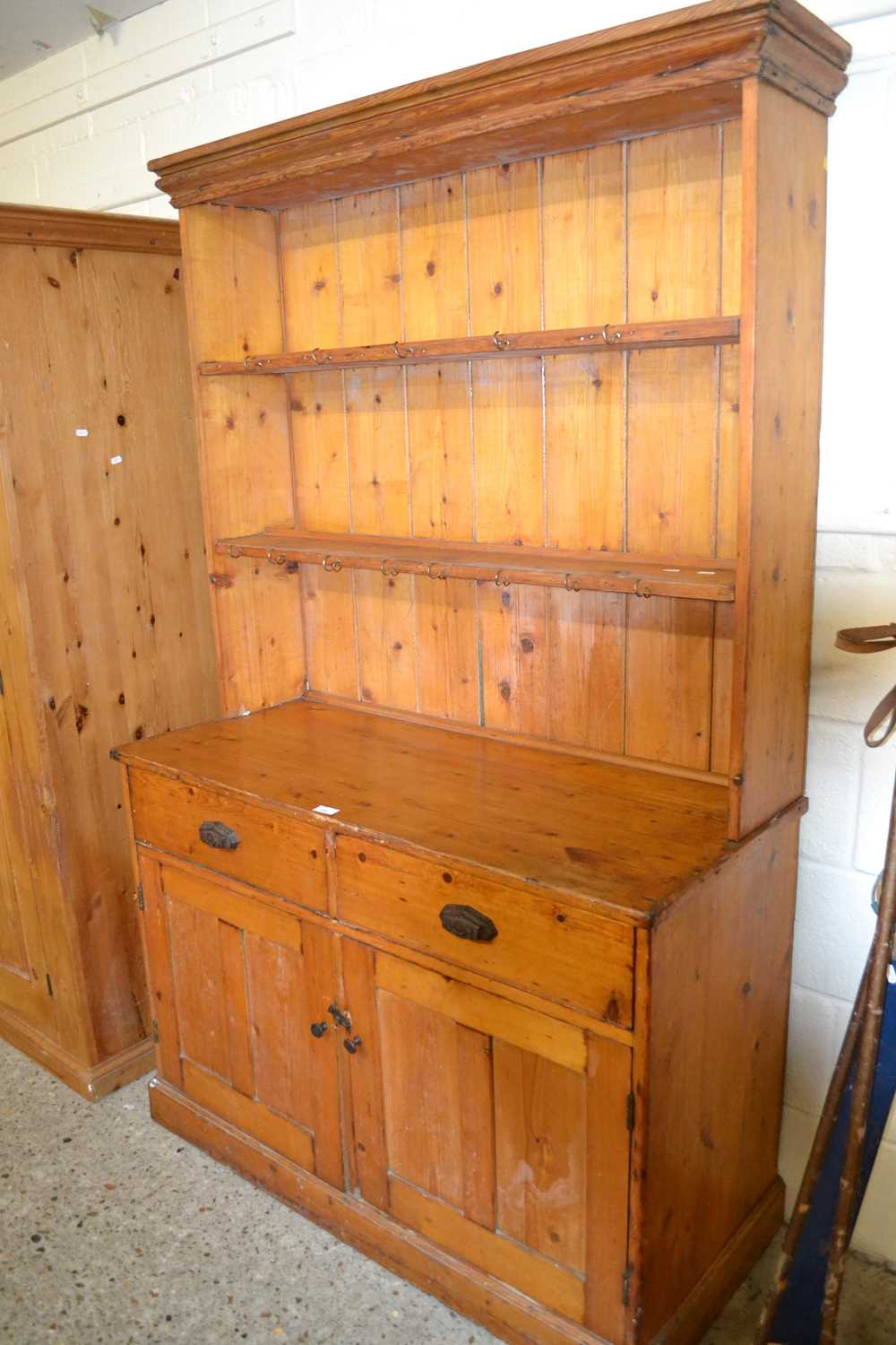 An early 20th Century pine kitchen dresser formed of two sections with drawer and cupboard base