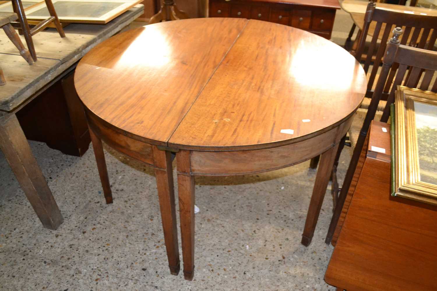 A pair of 19th Century mahogany demi lune tables forming a circular dining table, lacking any