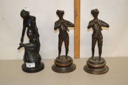 A group of three bronzed metal figures on circular plinth bases