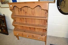 A modern pine wall shelf with three drawers