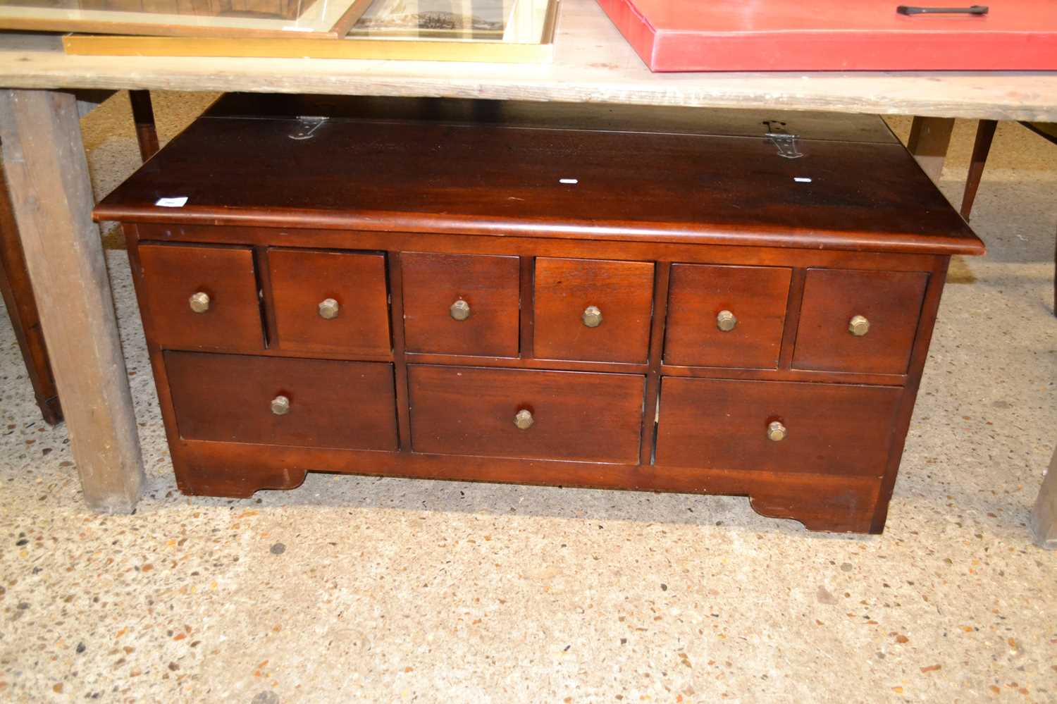 A modern nine drawer low chest with hinged lid