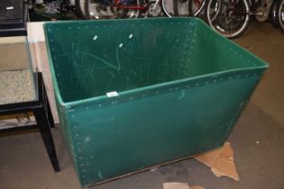 A plywood and green plastic laundry bin on casters