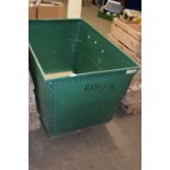 A plywood and green plastic laundry basket on casters