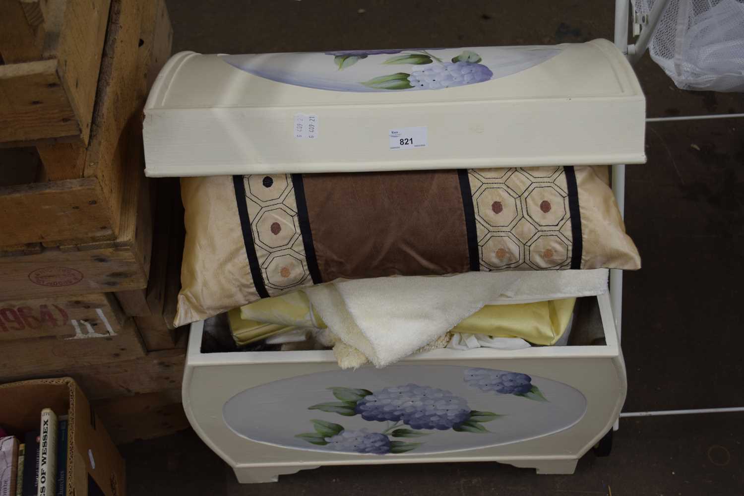 A cream painted domed trunk and a quantity of assorted household linens