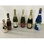 A group of six various bottles of champagne and sparkling wine