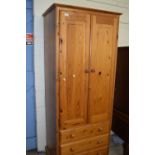 A narrow pine two door three drawer wardrobe