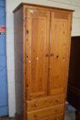 A narrow pine two door three drawer wardrobe