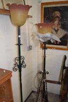 Two similar iron framed standard lamps with peach frilled glass shades