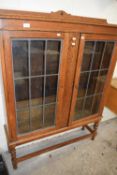 An early 20th Century oak lead glazed bookcase cabinet on barley twist legs