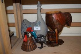 A pottery chicken together with a basket chicken and another small