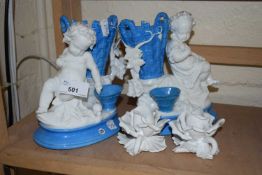 A pair of continental porcelain models of children with baskets of grapes together with two