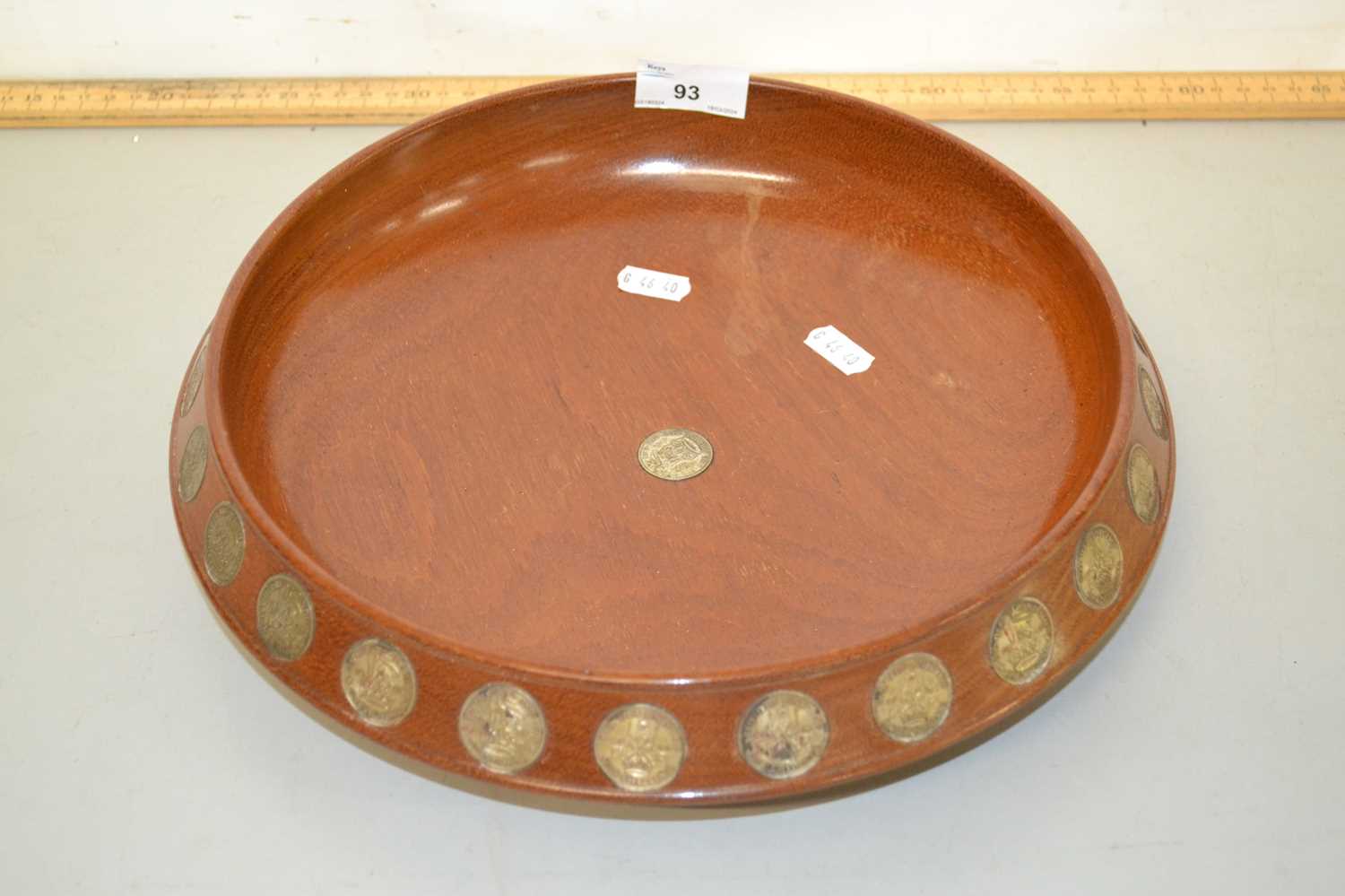 A hardwood fruit bowl decorated with inset shilling coins