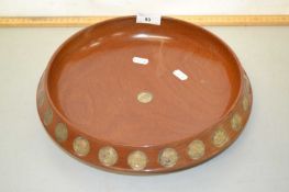 A hardwood fruit bowl decorated with inset shilling coins