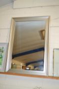 A large modern bevelled wall mirror in silvered finish frame