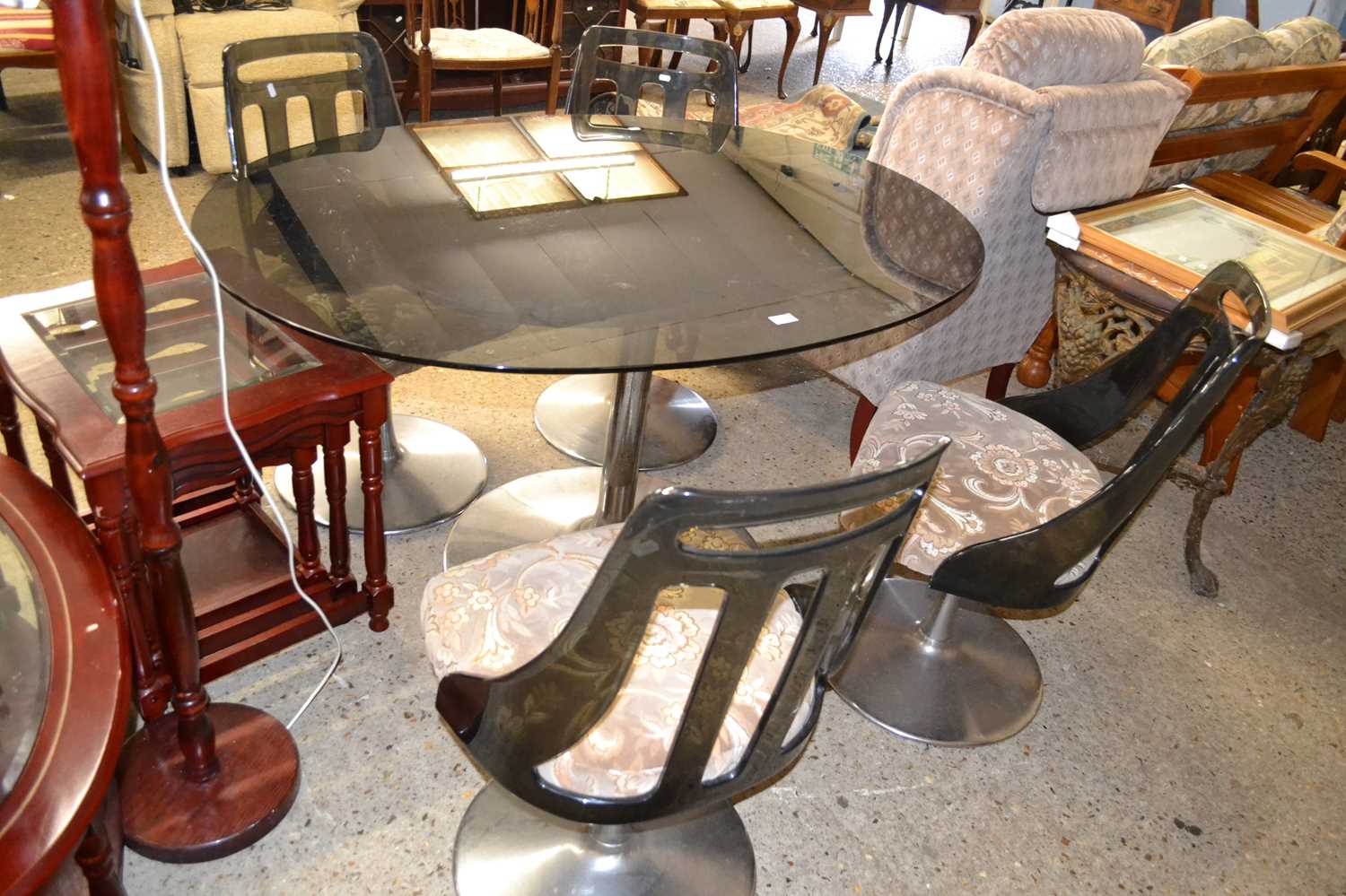 A retro pedestal chrome based dining table with smoked glass top together with a set of four