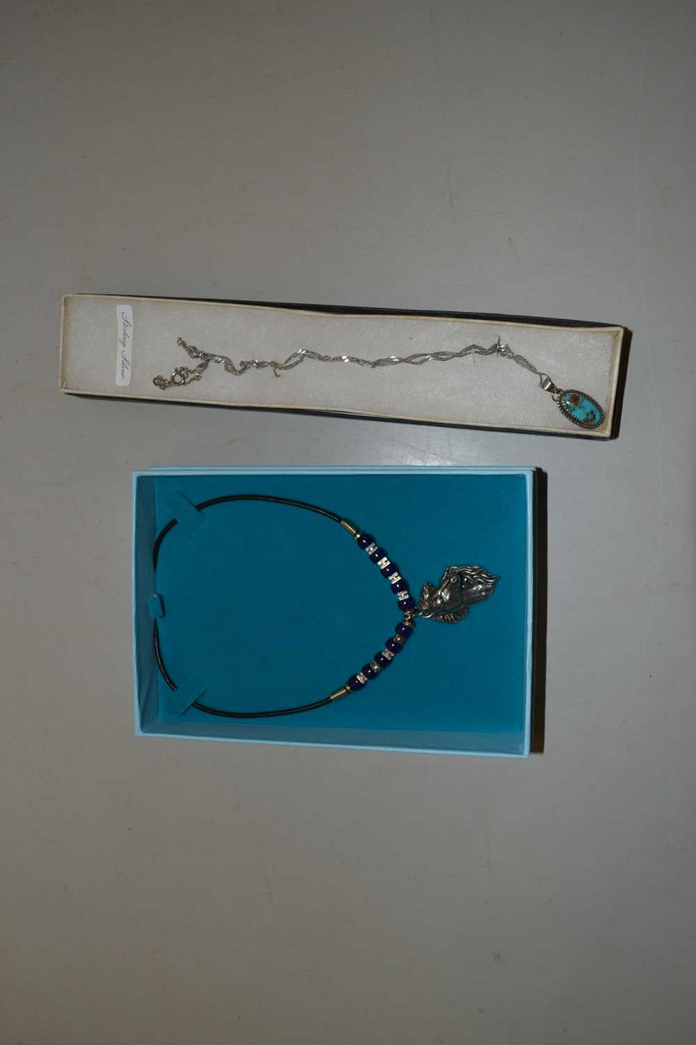 Mixed Lot: Small sterling silver pendant and chain together with a horses head pendant necklace