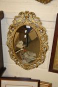An oval wall mirror in classical type pierced frame