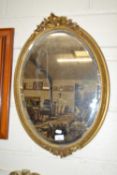 An early 20th Century oval bevelled wall mirror with ivy leaf decorated frame