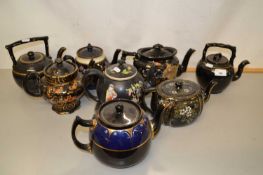 A group of various black, floral and gilt decorated Victorian teapots