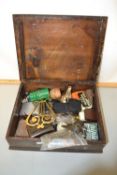 A small wooden box containing a range of mixed items to include small brass trivet, various buttons,