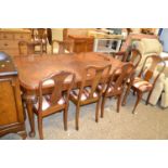 An early 20th Century walnut veneered extending dining table together with a harlequin set of