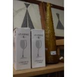 A tall conical amber glass decanter and a quantity of wine glasses, boxed