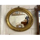 Victorian oval bevelled wall mirror set in a gilt frame with floral decoration