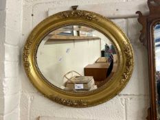 Victorian oval bevelled wall mirror set in a gilt frame with floral decoration